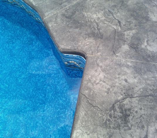 cantilevered concrete pool deck with rough stone texture pattern